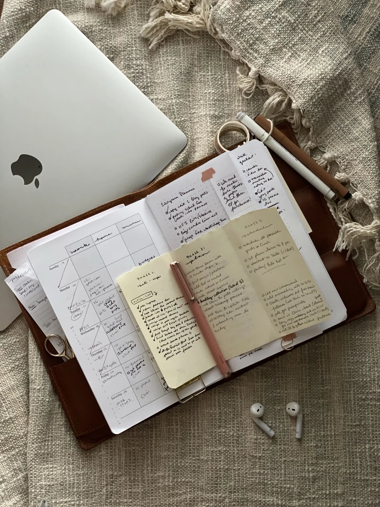 A goals spread in the planner beside AirPods